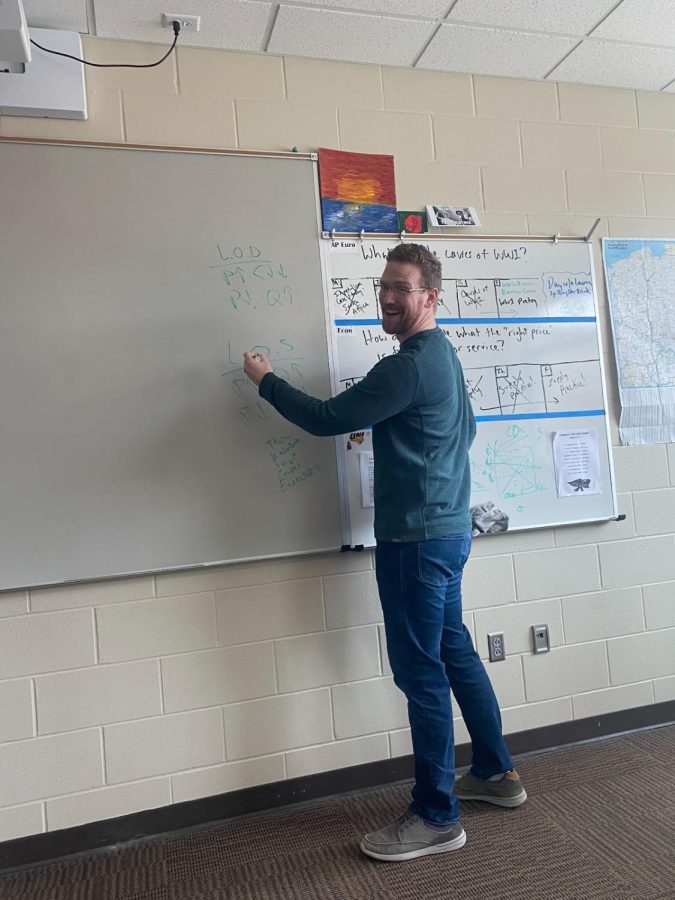 Social+studies+teacher+Nicholas+Covington+poses+against+the+whiteboard+in+his+classroom+after+writing+down+notes+for+his+economics+class.+Covington+said+that+it+was+tough+to+tell+everyone+he+was+leaving%2C+but+glad+they+all+understood.%0A%0A+%E2%80%9CThat+was+the+hardest+part+I+think%2C+telling+the+students+because+there+were+audible+gasps%2C%E2%80%9D+Covington+said.+%0A