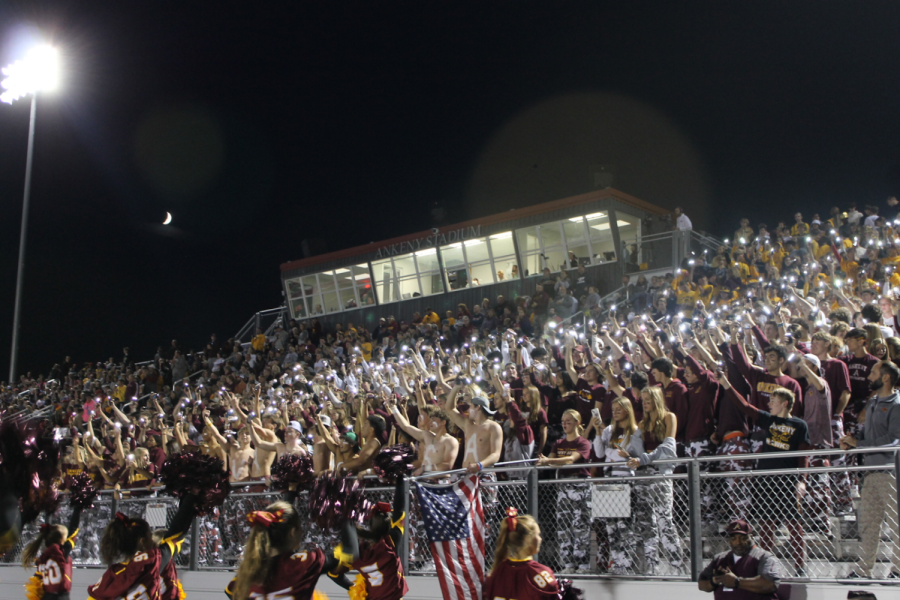 The AHS student section hold up flashlights during the Homecoming game against Valley High School at Ankeny’s stadium on Sept. 30, 2022.