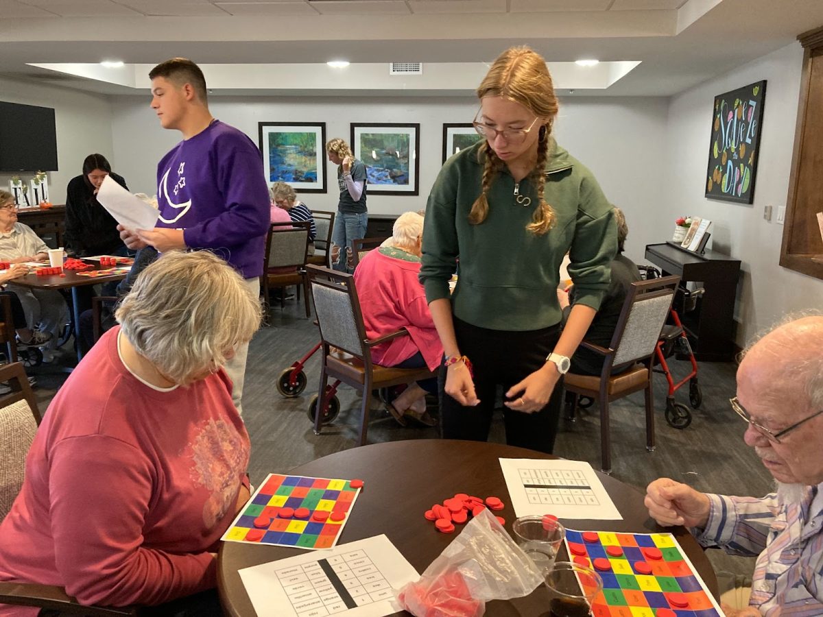 Junior Sammy Bryan helps the seniors at Rock Creek Senior Living Center with bingo. Three rounds were played in total. Players appeared competitive.