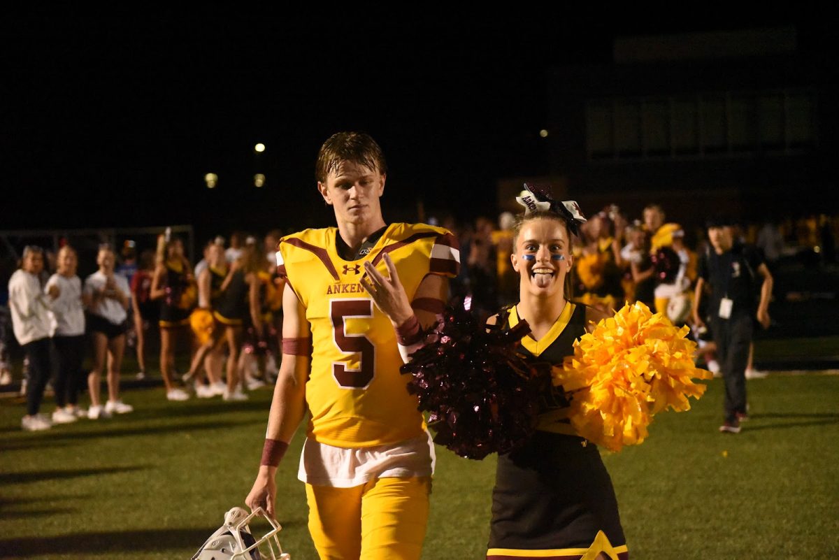 Seniors Caden Henkes and Elyse Enskat celebrate after the Hawks first win on the year.