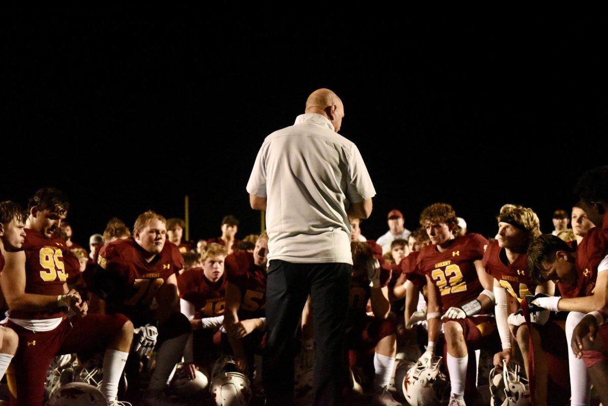 Head Coach Jeff Bauer talks to his players after a 38-22 victory over Iowa City West