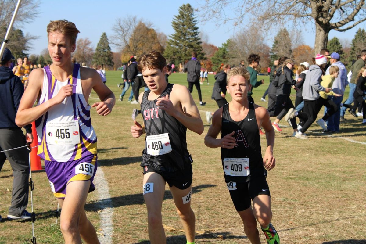 Junior Brett Augustine (bib number 409) passes runners from Mason City and Indianola at about the 4k mark of the race.