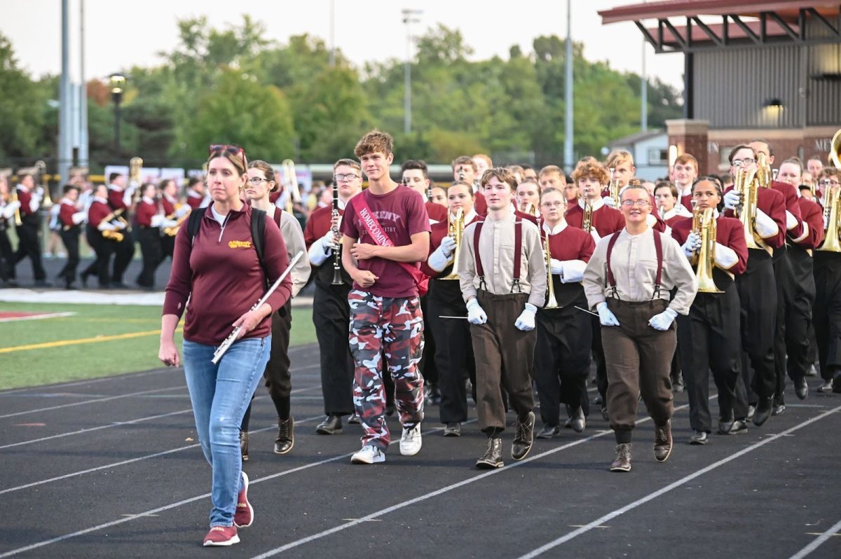 Fine arts teacher and assistant music director Kelly Weber leads the band after a pregame performance on Sept. 27.