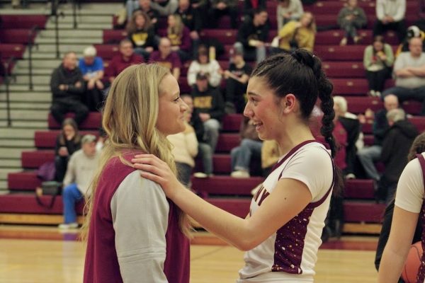 Codee Myers talks to senior Grace Buch during a break in play. Myers has coached for the girls’ basketball program since the 2021-22 season.