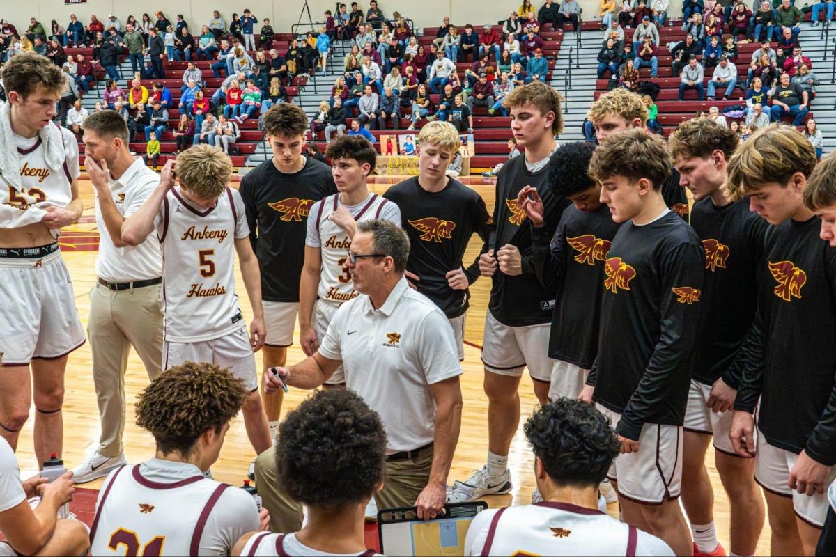 The Hawks huddle around coach Brandt Carlson. Photo By KingMason Caldwell-Teamah. (OneShot)