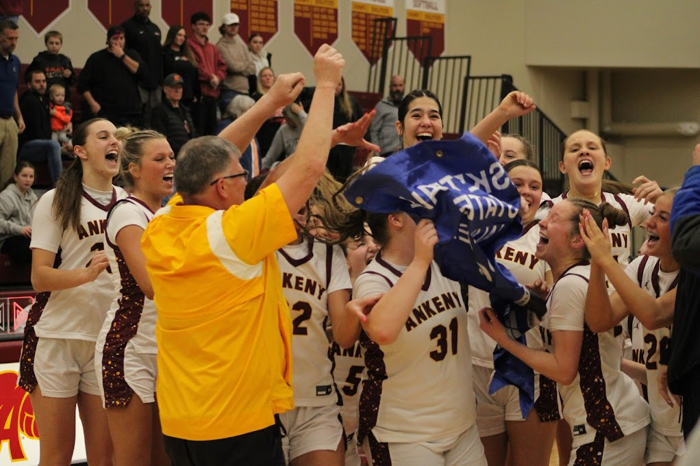 The Ankeny girls basketball team receives its state tournament qualifier banner from Ankeny athletic director Mike Bakker. The Hawkettes beat the No. 11 Sioux City East Raiders 60-30 in the last home game for five Ankeny seniors.