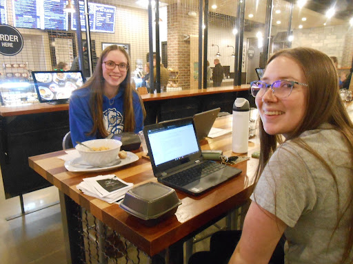 2025-2026 Editor-in-Chief Lydia Gerety sits with 2026-2027 Editor-in-Chief Ashley Howard at a fundraiser for The Talon, Ankeny High School’s student newspaper. Photo by River Phillips.