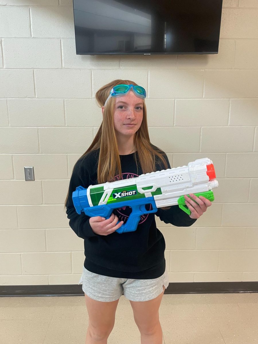 Sophomore Lily Bell posing as a player in the senior assassin game. Seniors participating in the game eliminate others by squirting them with a water gun, and can wear goggles for immunity against others. “People did have to go out and buy [water] guns, but most people have the googles at home, but you don’t even have to use a gun, you can use water of any sort,” senior Gwyn Christensen said.
